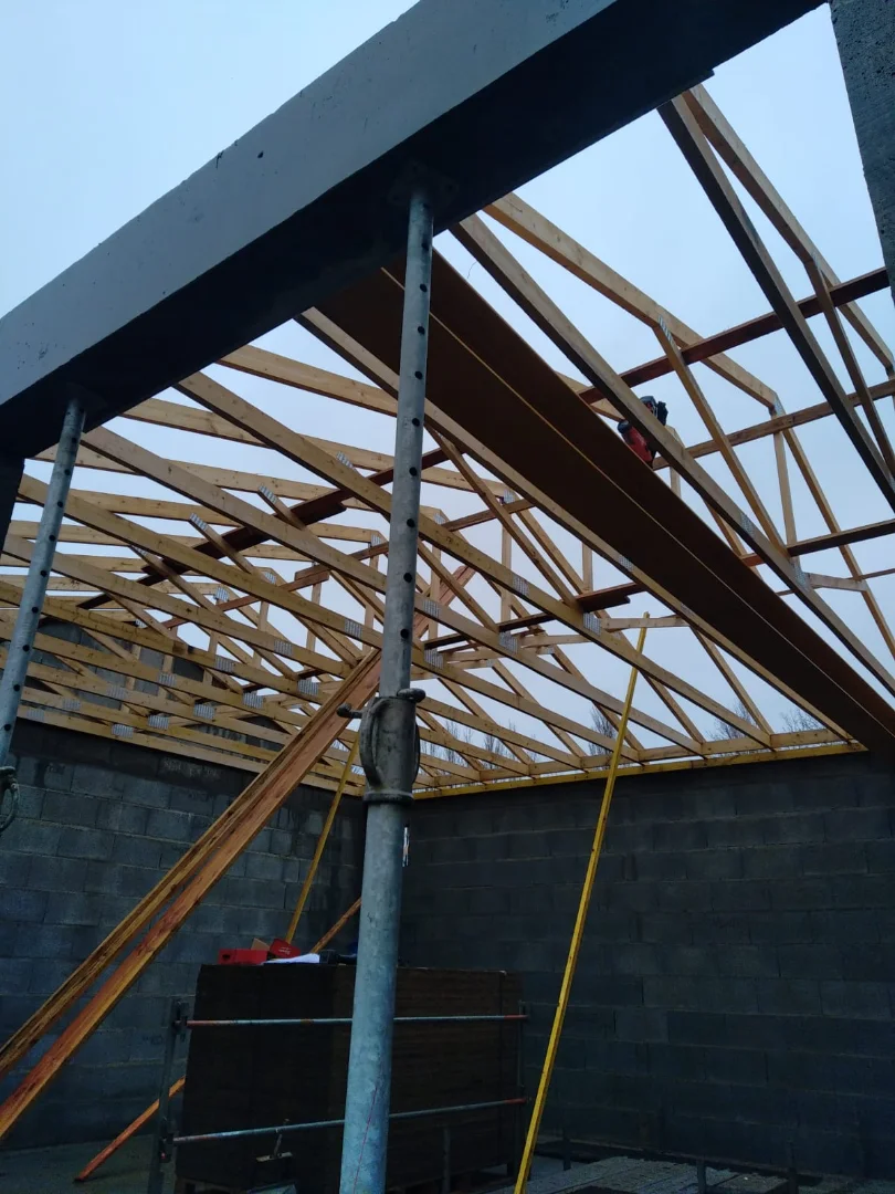 Charpente en bois à fermettes en cours de construction. Une chantier d'une maison individuelle réalisé par Actiba Menuiseries