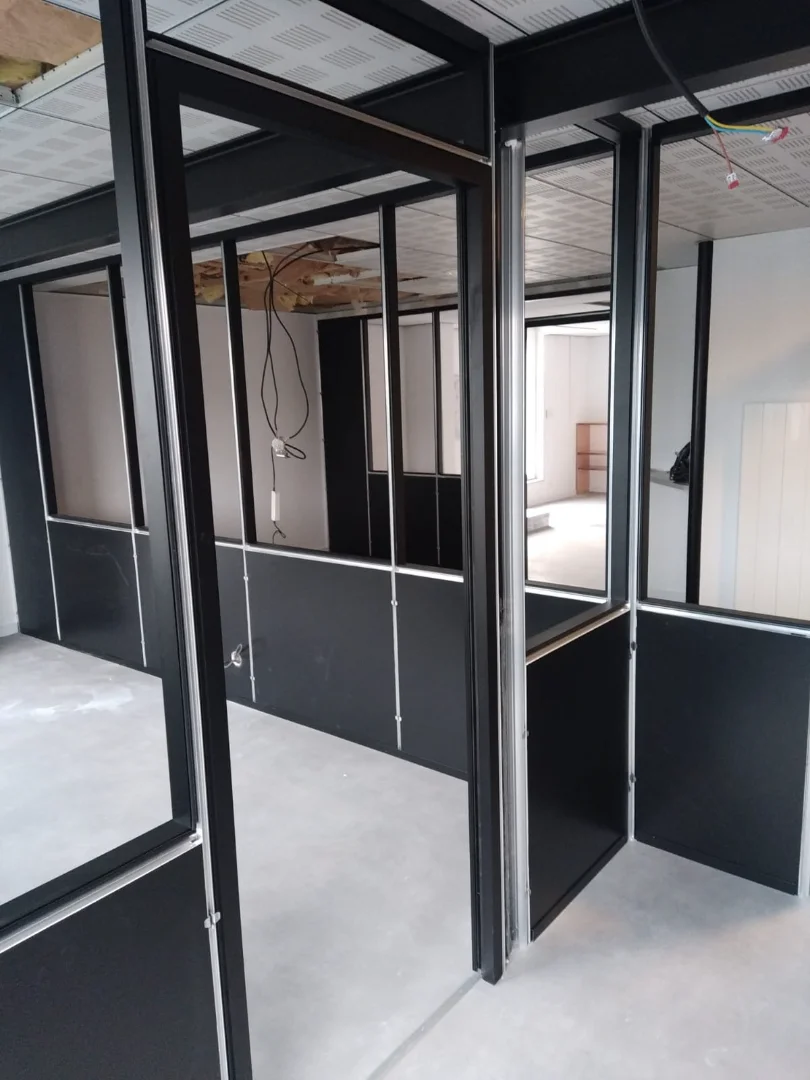 Cloisons semi-vitrées noires installées par Actiba Menuiseries dans des bureaux