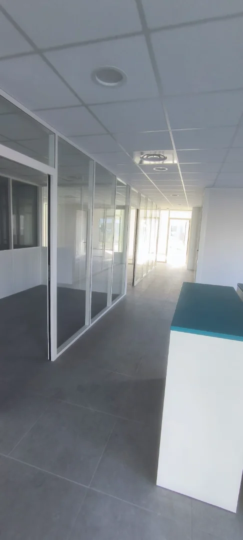 Cloisons vitrées modernes installées par Actiba Menuiseries dans des bureaux, favorisant le passage de la lumière entre les pièces