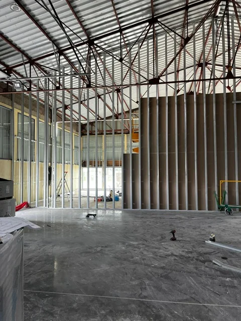 Réalisation de l'ossature d'une cloison sèche grande hauteur dans un bâtiment industriel