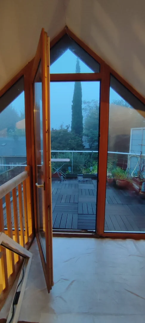 Vue intérieure d'une porte fenêtre en bois qui n'est plus au goût du jour, avant le passage d'Actiba Menuiseries