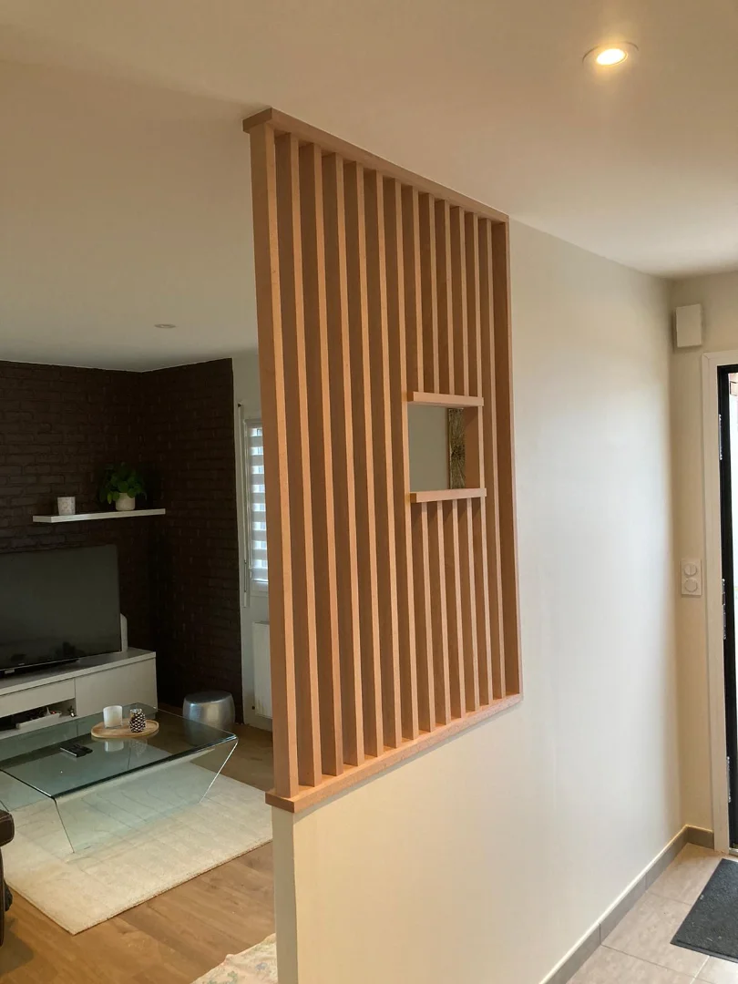 Claustra bois moderne pour séparer l’entrée du salon et structurer l’espace avec élégance.