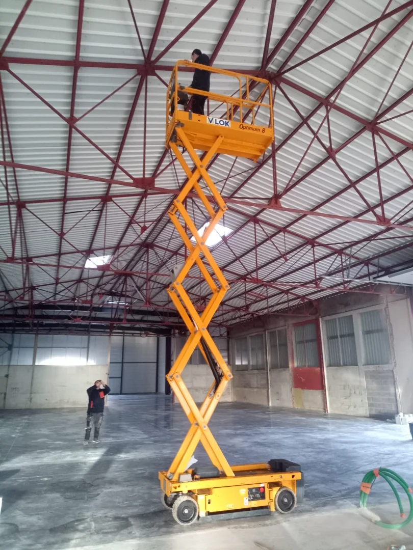 Ouvrier Actiba sur une nacelle élévatrice pour réaliser le chantier d'une cloison sèche grande hauteur.