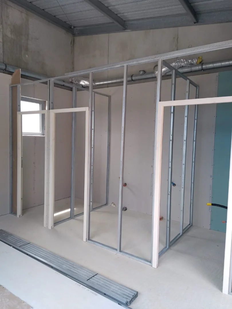 Préparation de l'ossature d'une cloison sèche avant la pose par les menuisiers de l'isolation et des plaques de plâtre.r