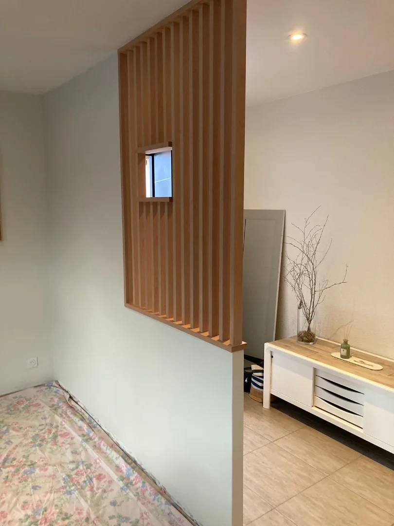 Cloison claustra bois sur mesure, parfaite pour délimiter l'entrée et le séjour tout en laissant passer la lumière.