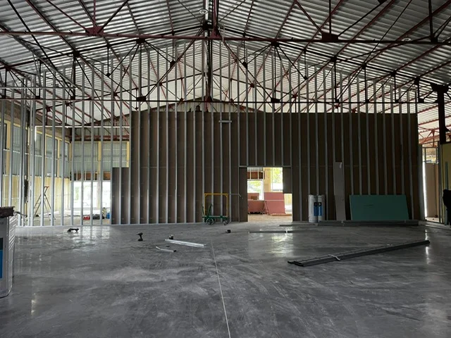 Vue éloignée montrant la très grande hauteur de la future cloison réalisée dans un bâtiment industriel.